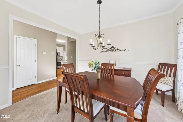 a dining room with furniture a chandelier and wooden floor