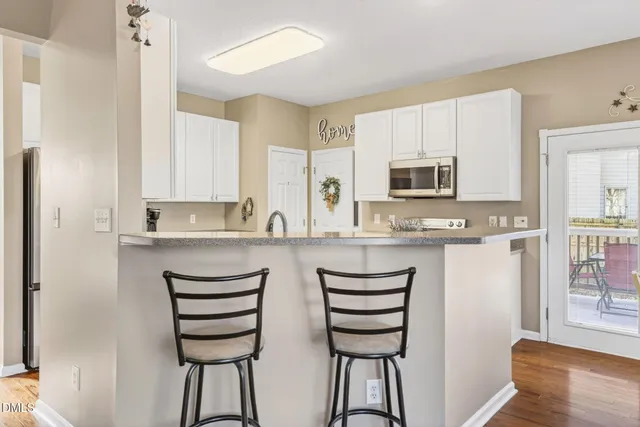 a kitchen with stainless steel appliances white cabinets and a stove top oven