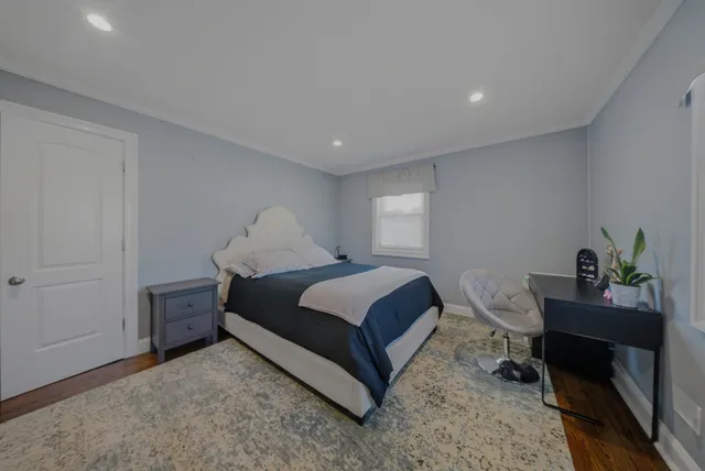 a bedroom with a bed table chair and a window