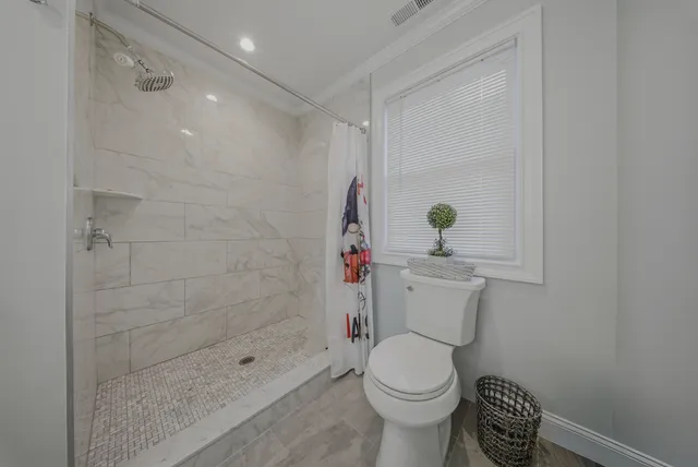 a bathroom with a toilet and a shower