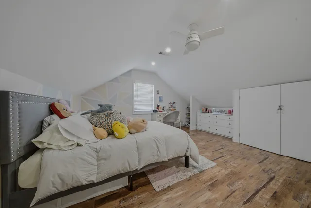 a bedroom with a bed and wooden floor