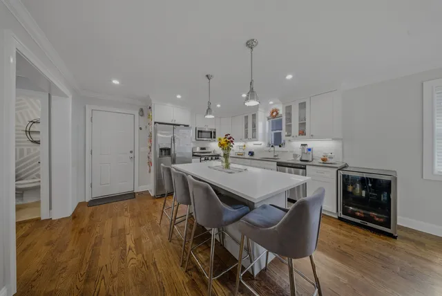 a kitchen with kitchen island a stove a table and chairs in it