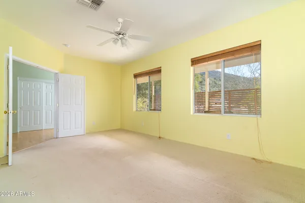 an empty room with a ceiling fan and a window