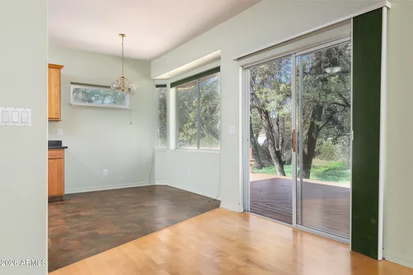a view of entryway with kitchen view and wooden floor