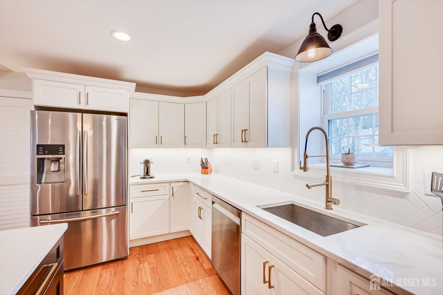 152 4th Street Edison, NJ 08837 - Photo 19 of 37 a kitchen with a sink a refrigerator and cabinets
