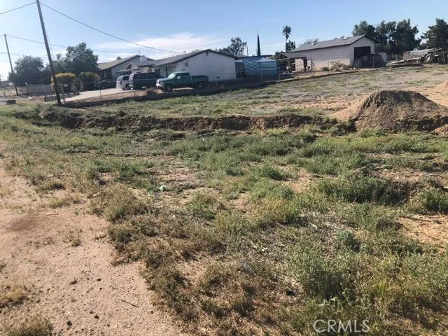 a view of a dry yard with wooden fence