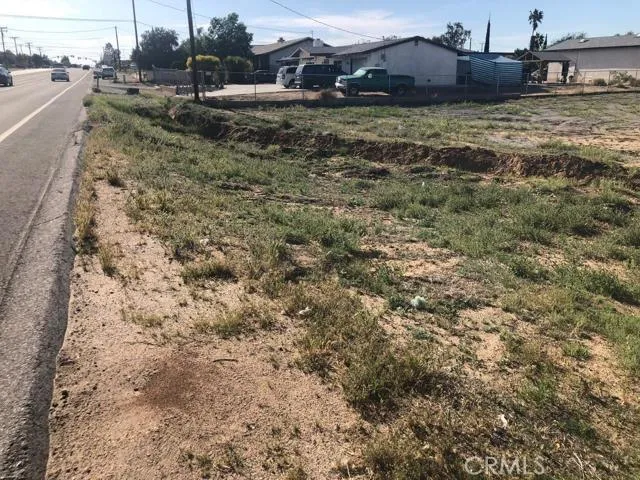a view of a dry yard with wooden fence
