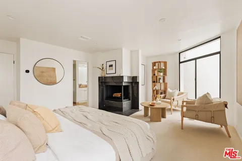 a bedroom with a bed mirror and a large window