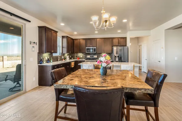 a dining table with kitchen view and wooden floor