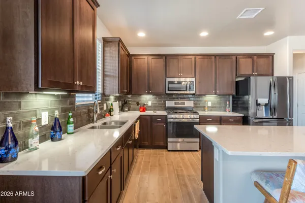 a kitchen with kitchen island a large counter top space appliances and cabinets