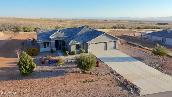 an aerial view of a house with a yard and ocean view