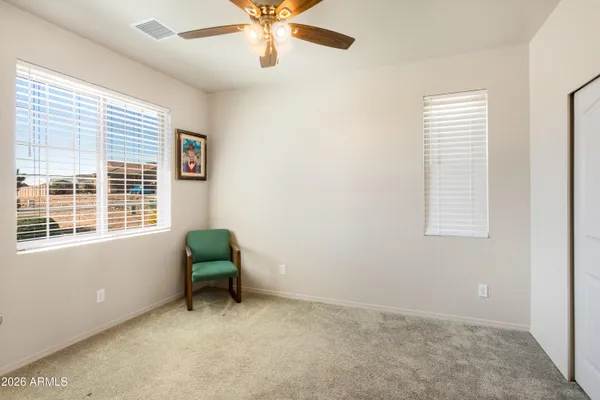 an empty room with windows and fan