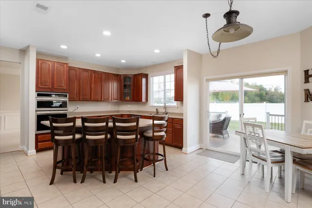 a kitchen with granite countertop a table chairs sink and cabinets