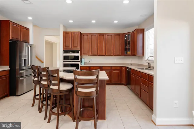 a kitchen with stainless steel appliances a table and chairs in it