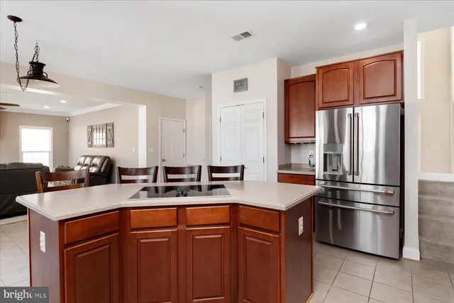 a kitchen with stainless steel appliances granite countertop a refrigerator a sink a stove with wooden cabinets