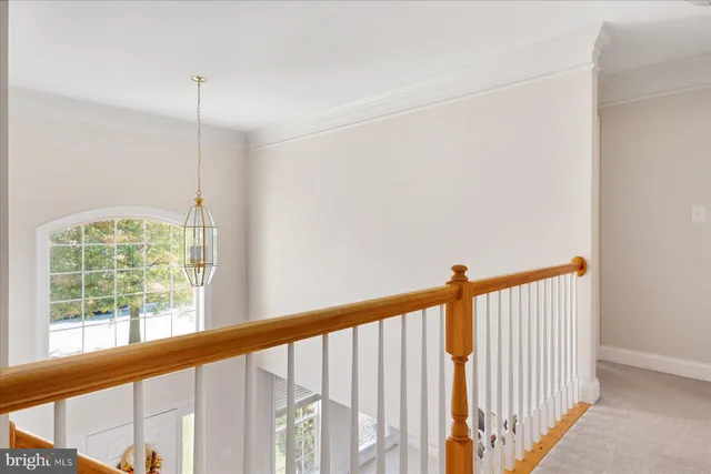 a view of staircase with railing and white walls