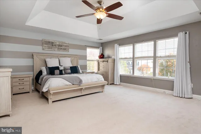 a bedroom with a large bed and a chandelier fan