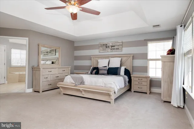 a spacious bedroom with a bed and a chandelier