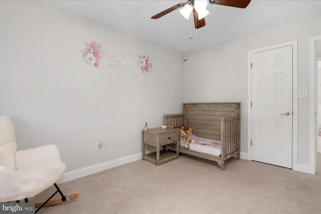 a bedroom with furniture and a chandelier fan