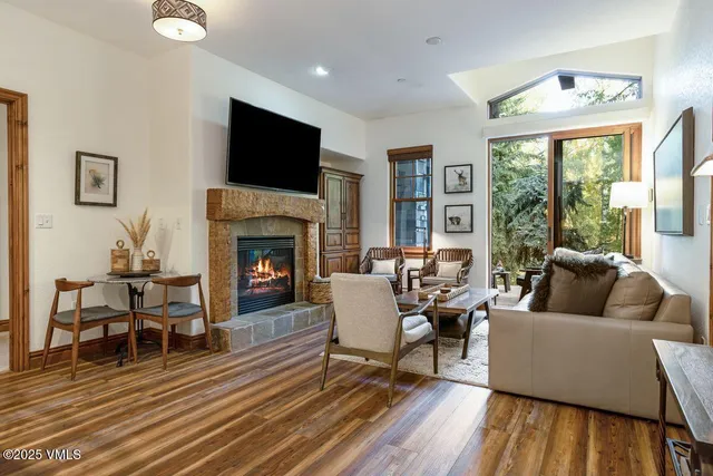 a living room with furniture a flat screen tv and a fireplace
