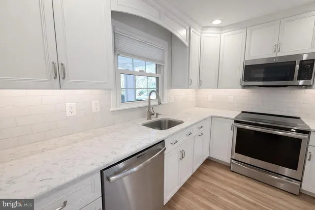 a kitchen with stainless steel appliances granite countertop a sink stove and microwave