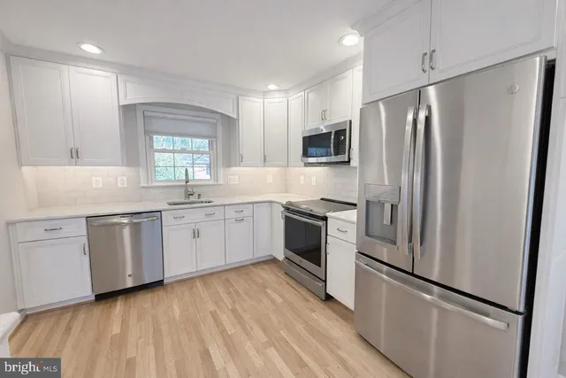 a kitchen with stainless steel appliances a refrigerator sink and microwave