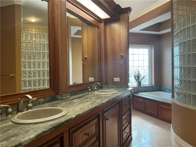 a bathroom with a granite countertop sink and a bathtub