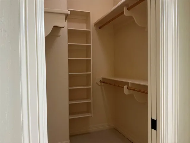 a view of walk in closet with empty racks