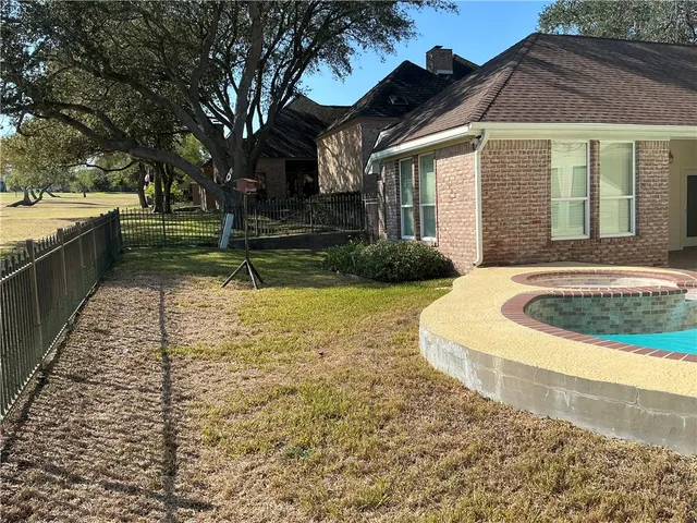 a view of a house with backyard and tree