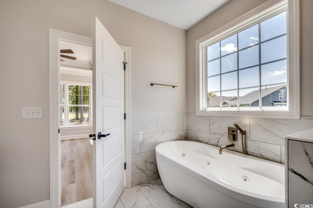 1007 Brood Court Conway, SC 29526 - Photo 20 of 40 Full bathroom with a soaking tub, tile walls, and marble finish floor