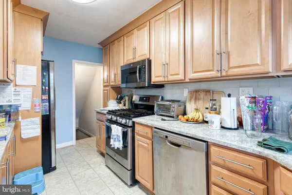 a kitchen with stainless steel appliances granite countertop a stove sink and cabinets