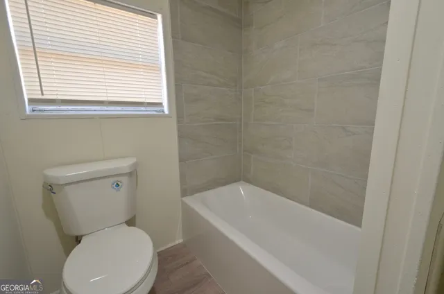 a white toilet sitting next to a bath tub