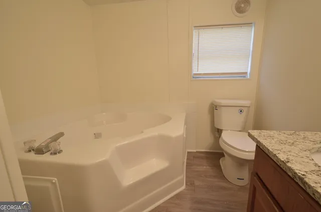 a bath room with a toilet and a bath tub