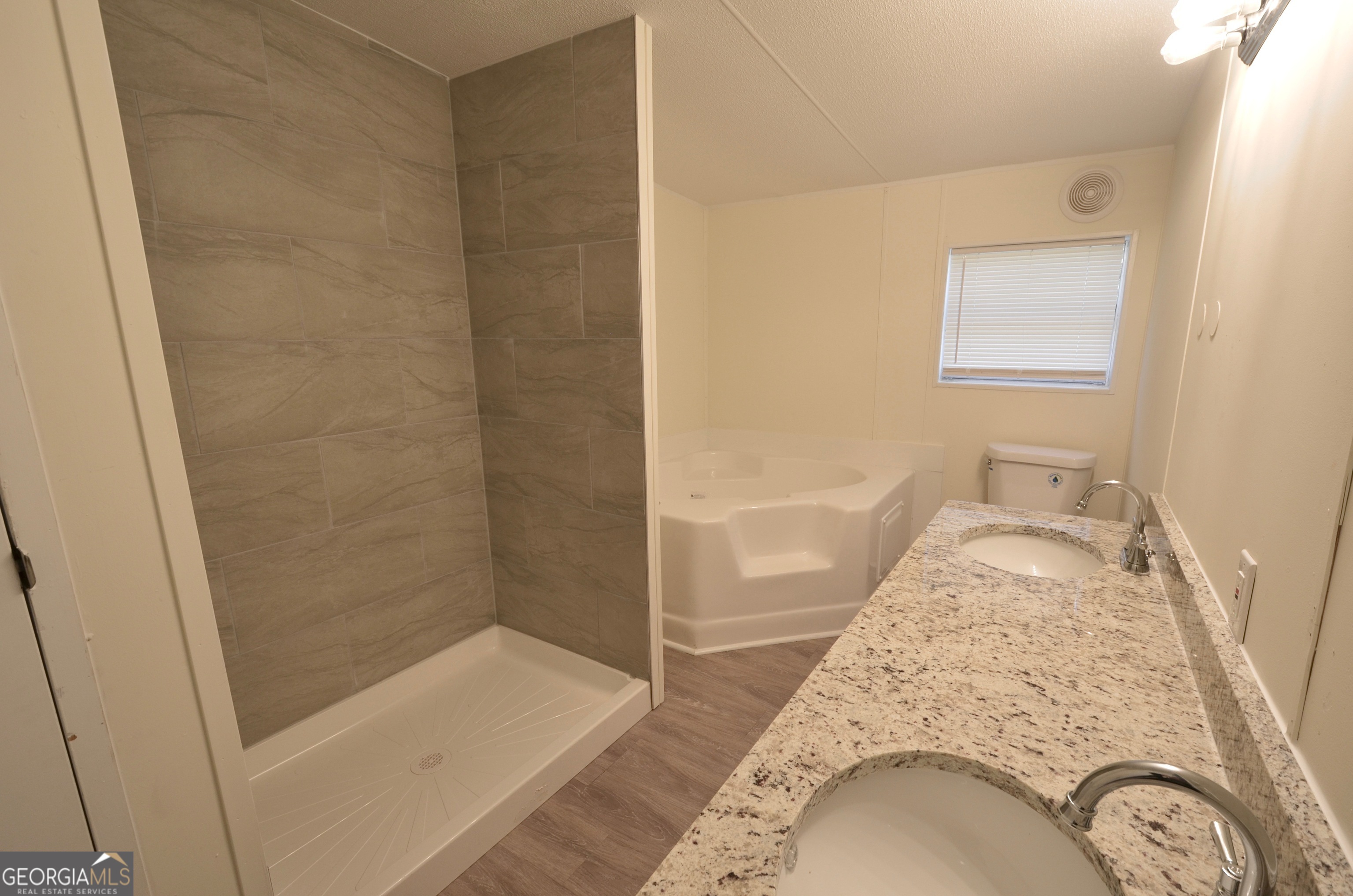 722 Brower Court Dublin, GA 31021 - Photo 16 of 27 a bathroom with a granite countertop sink a mirror and shower