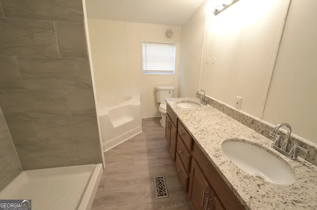 a bathroom with a granite countertop tub sink and mirror