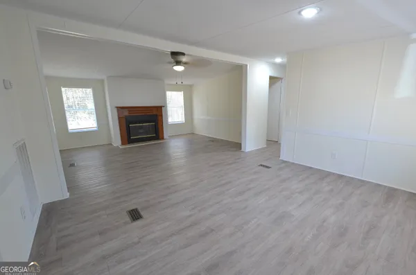 an empty room with wooden floor and fireplace