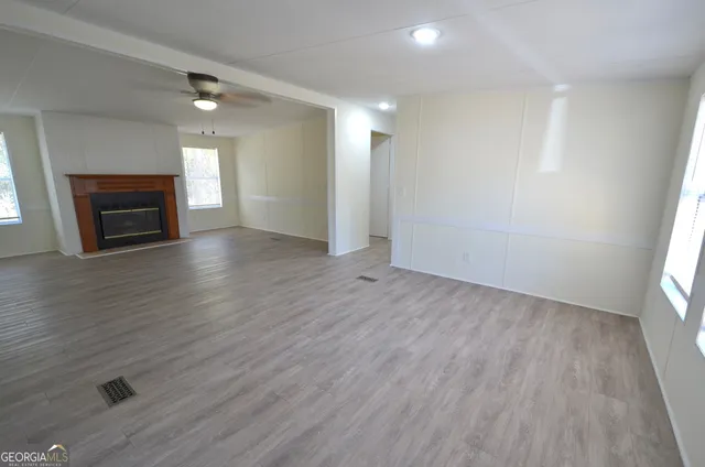 an empty room with wooden floor and fireplace