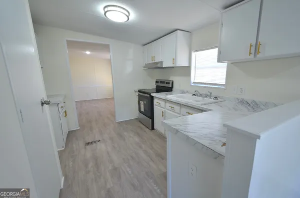 a kitchen with a sink a stove a refrigerator and cabinets