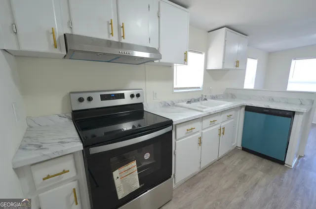 a kitchen with cabinets appliances and a sink