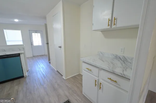 an entryway with wooden floor and cabinet