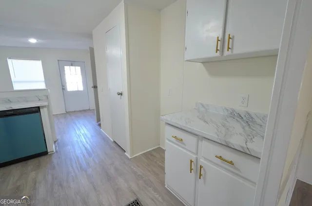 an entryway with wooden floor and cabinet