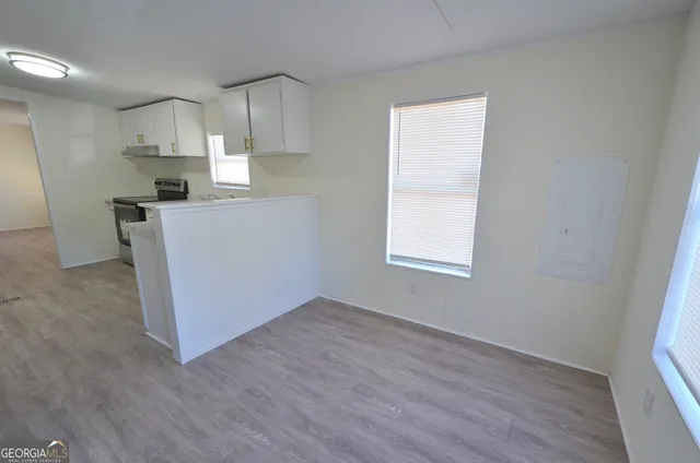 a view of kitchen with wooden floor electronic appliances and window