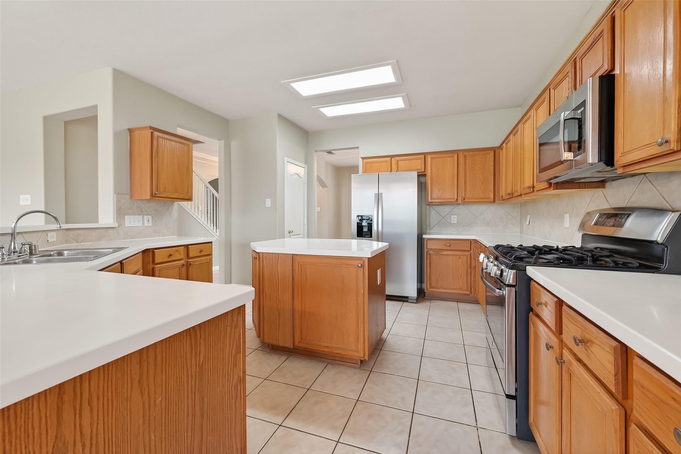 16639 Village View Trail Sugar Land, TX 77498 - Photo 17 of 50 a kitchen with stainless steel appliances a sink stove and a refrigerator