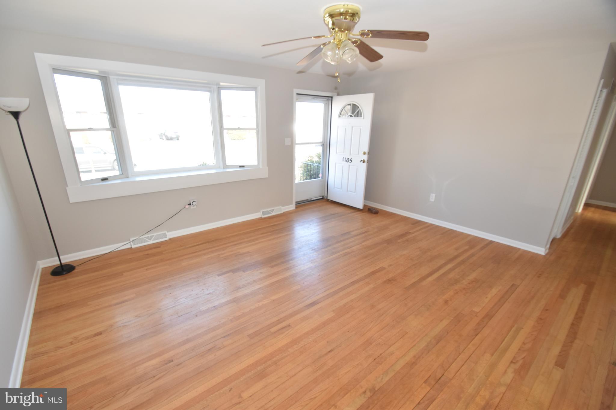 1105 Ralph Road Newark, DE 19713 - Photo 4 of 41 an empty room with wooden floor chandelier fan and windows