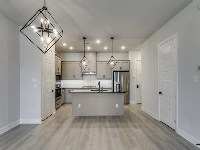a kitchen with stainless steel appliances granite countertop a sink and stove top oven