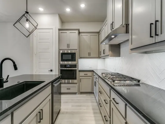 a kitchen with stainless steel appliances granite countertop a refrigerator a sink and a refrigerator