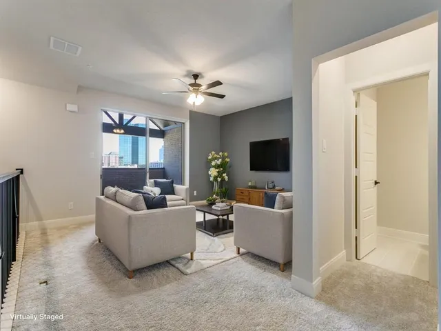 a living room with furniture and a ceiling fan
