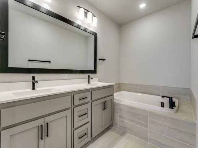 a bathroom with a tub sink and mirror