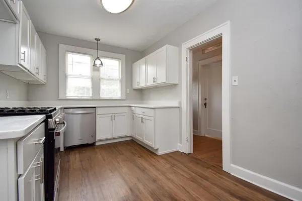 a white kitchen with granite countertop stainless steel appliances