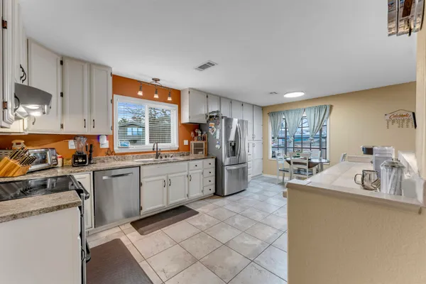 a kitchen filled counter top space a sink cabinets and appliances
